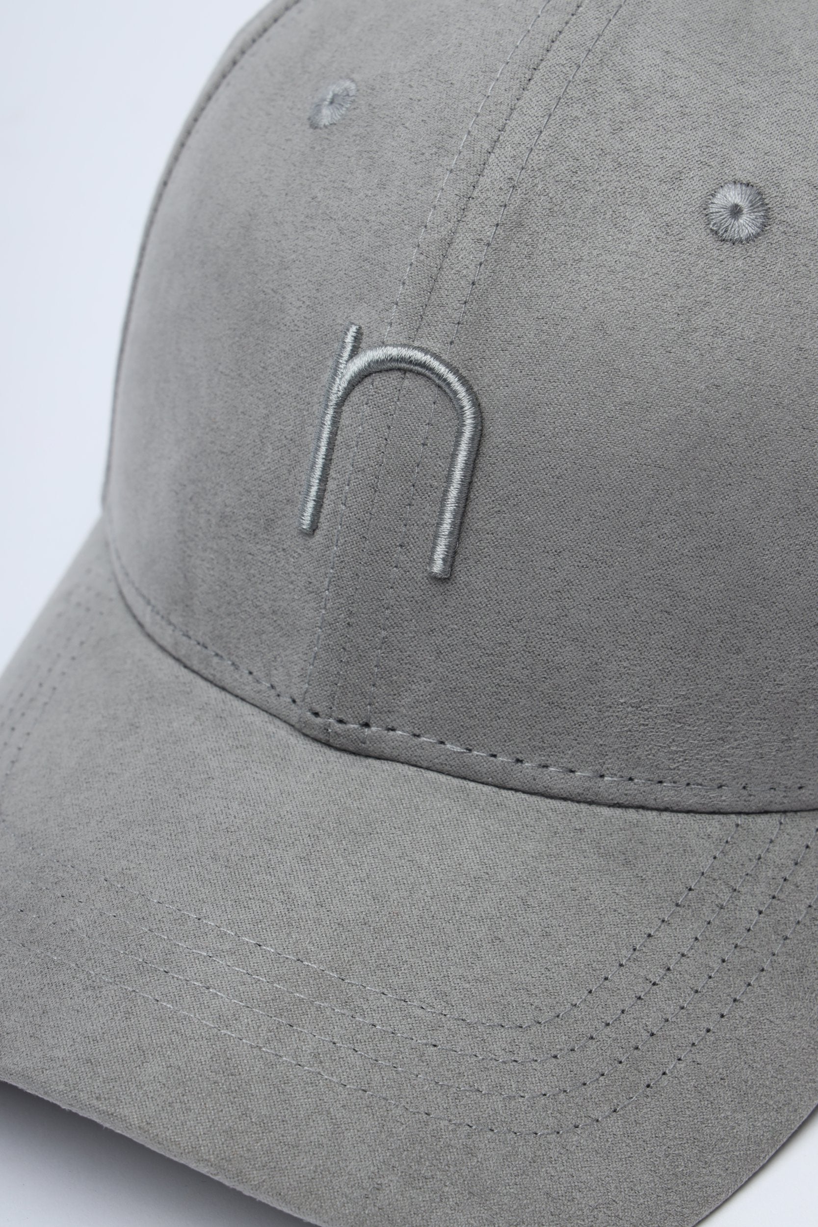 Side profile of Jet Set cap – light grey suede with curved brim