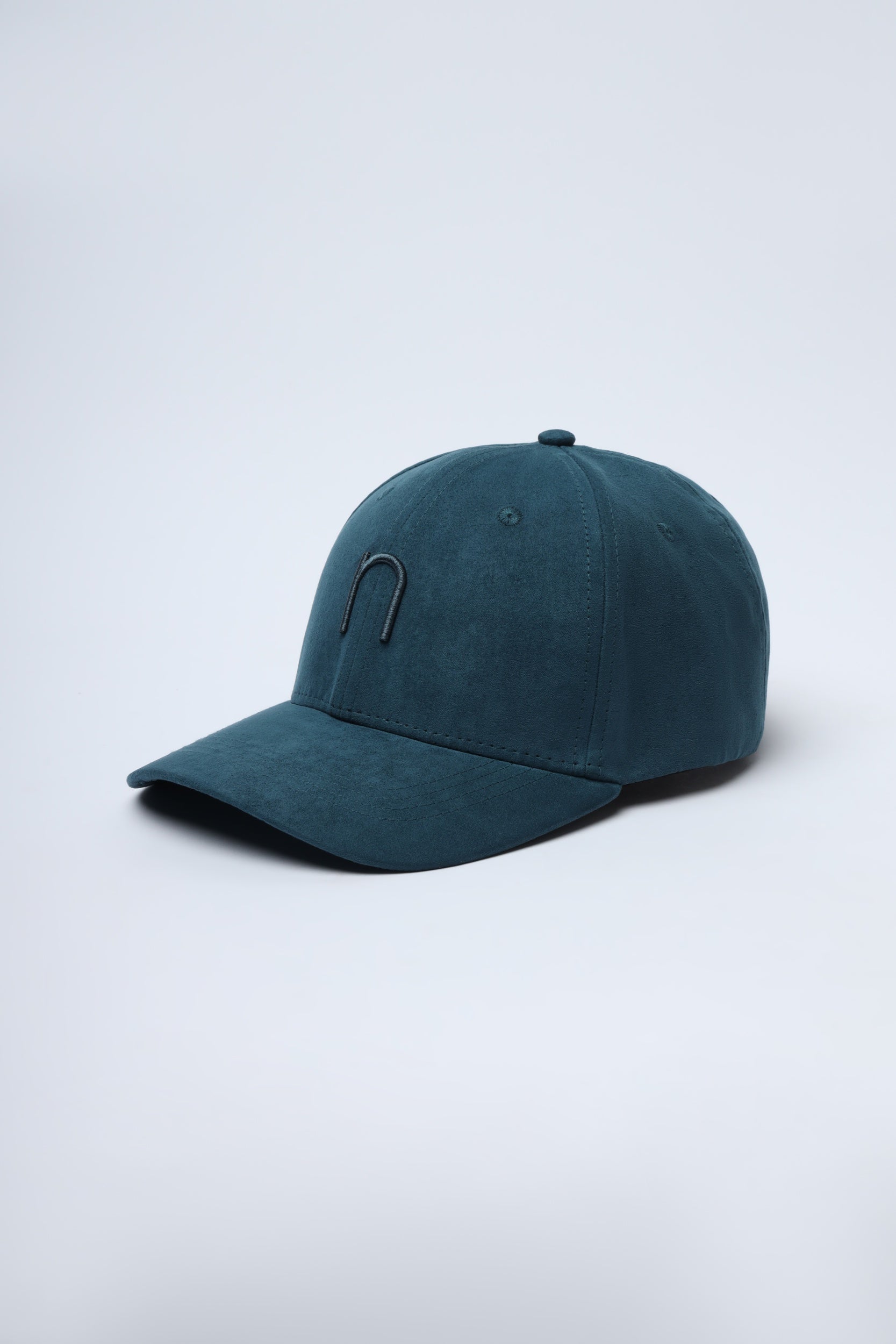 Side angle view of bottle green Noggah cap on wooden surface