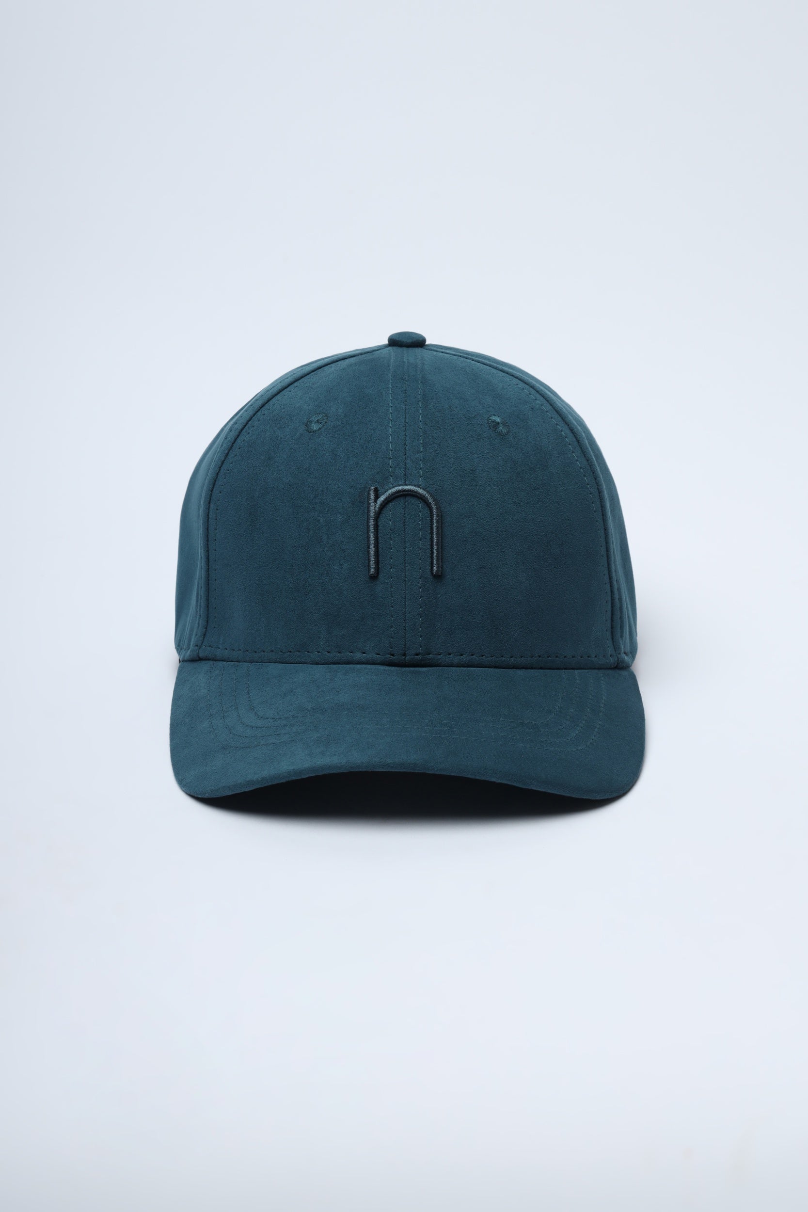 Lifestyle image of model wearing bottle green suede cap from Noggah