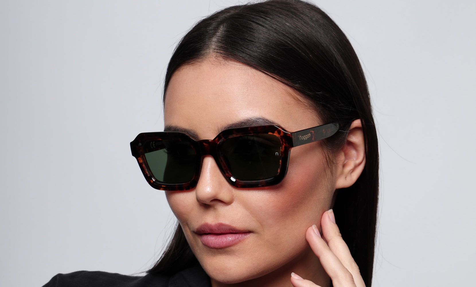 Side profile of Orbit Tortoise Drift sunglasses (NS1007TFGL) with tortoise-shell frame, glass lenses, and a sleek urban backdrop